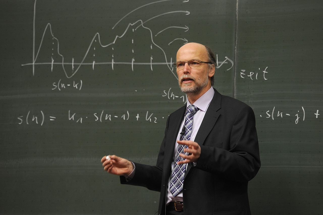 A lecturer standing in front of a blackboard