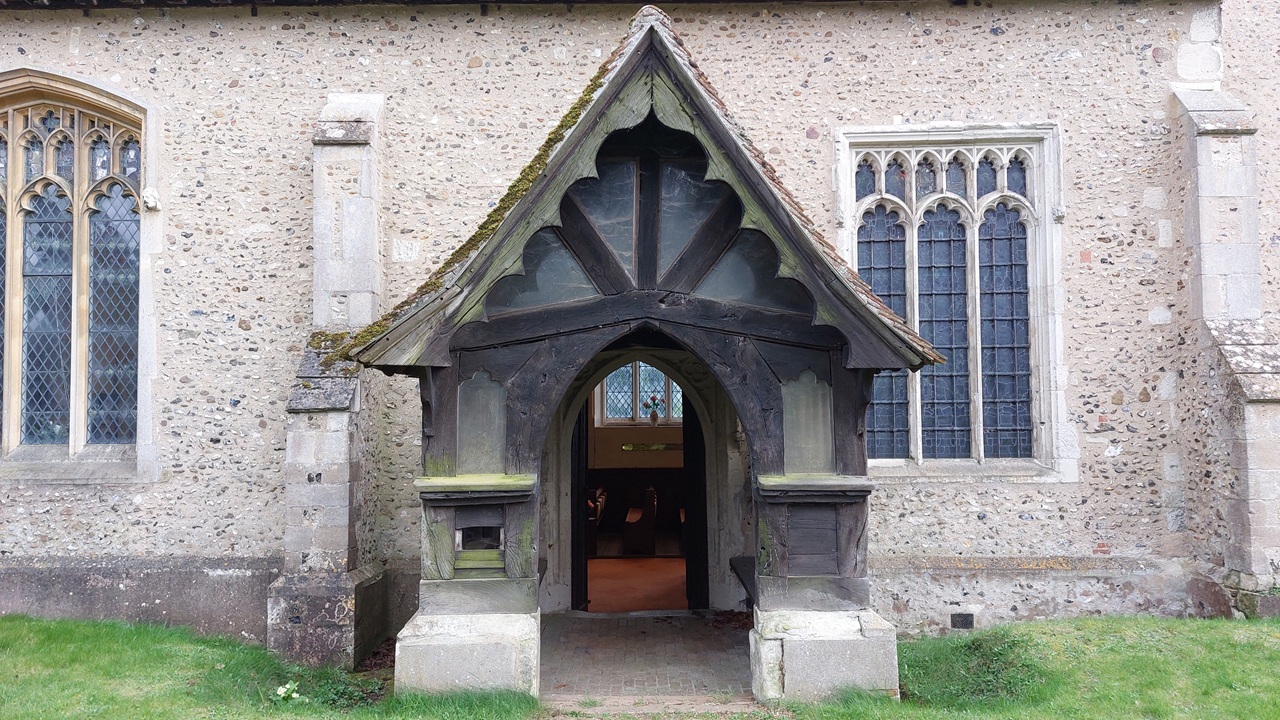 A church porch leading to an open door.